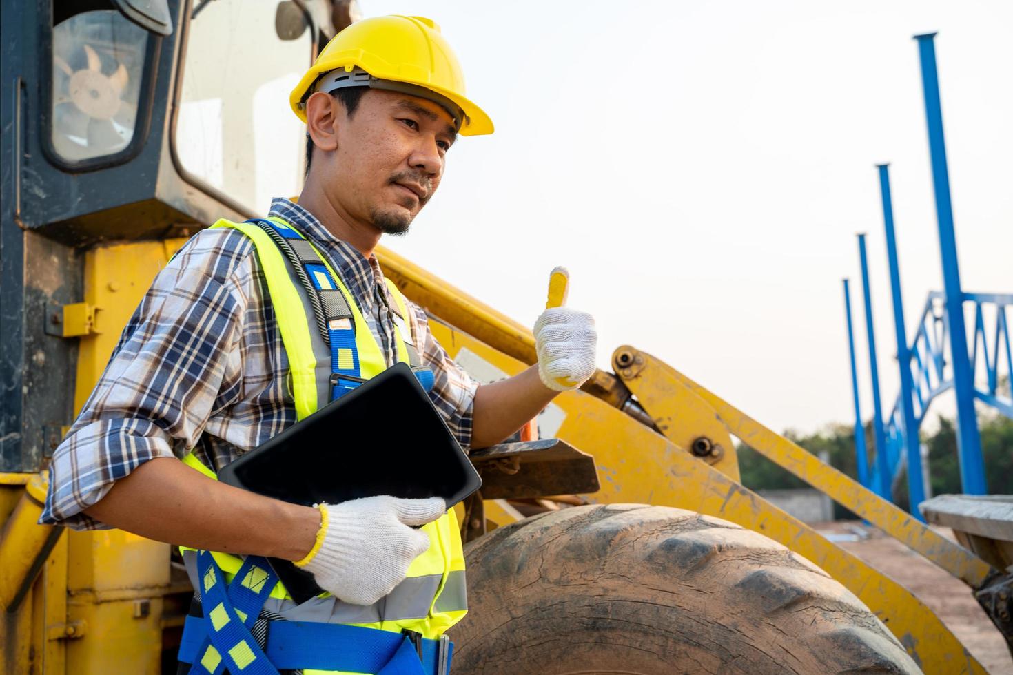 Construction worker next to backhoe loader photo