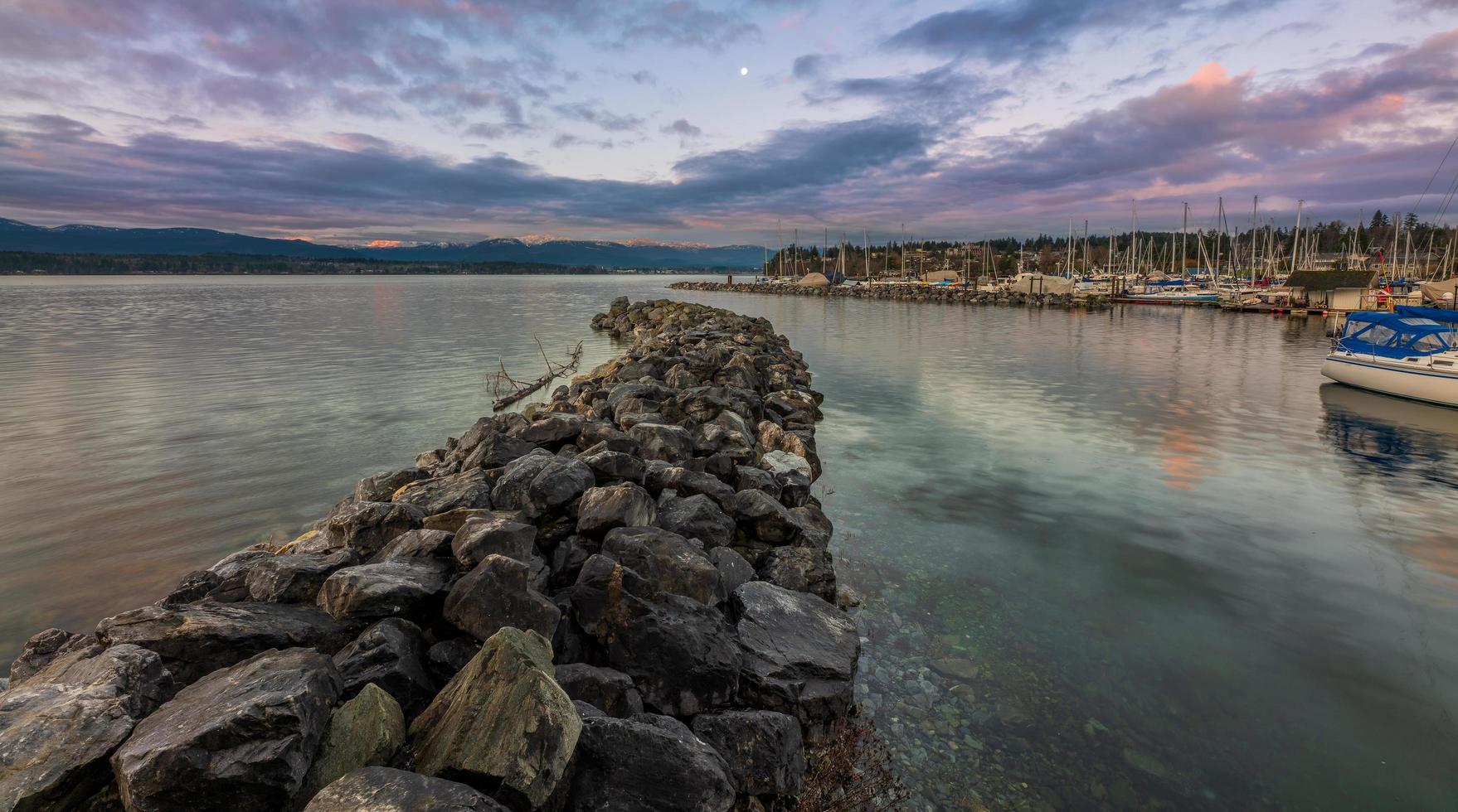 Gray rocks near body of water under blue sky photo