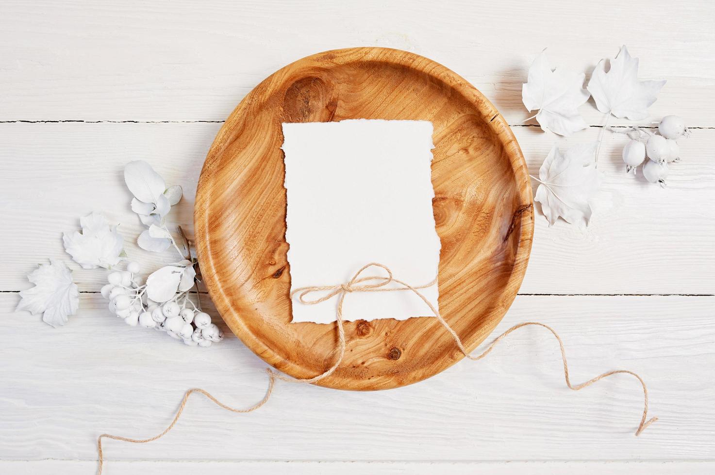 papel en blanco en un tazón de madera sobre una mesa de madera foto