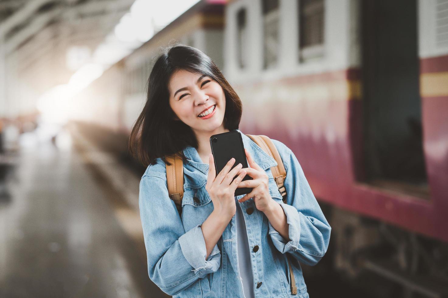 feliz mujer asiática en la estación de tren foto