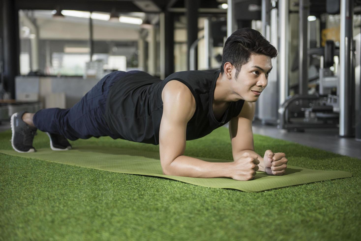 hombre en pose de tablón de yoga en el gimnasio foto