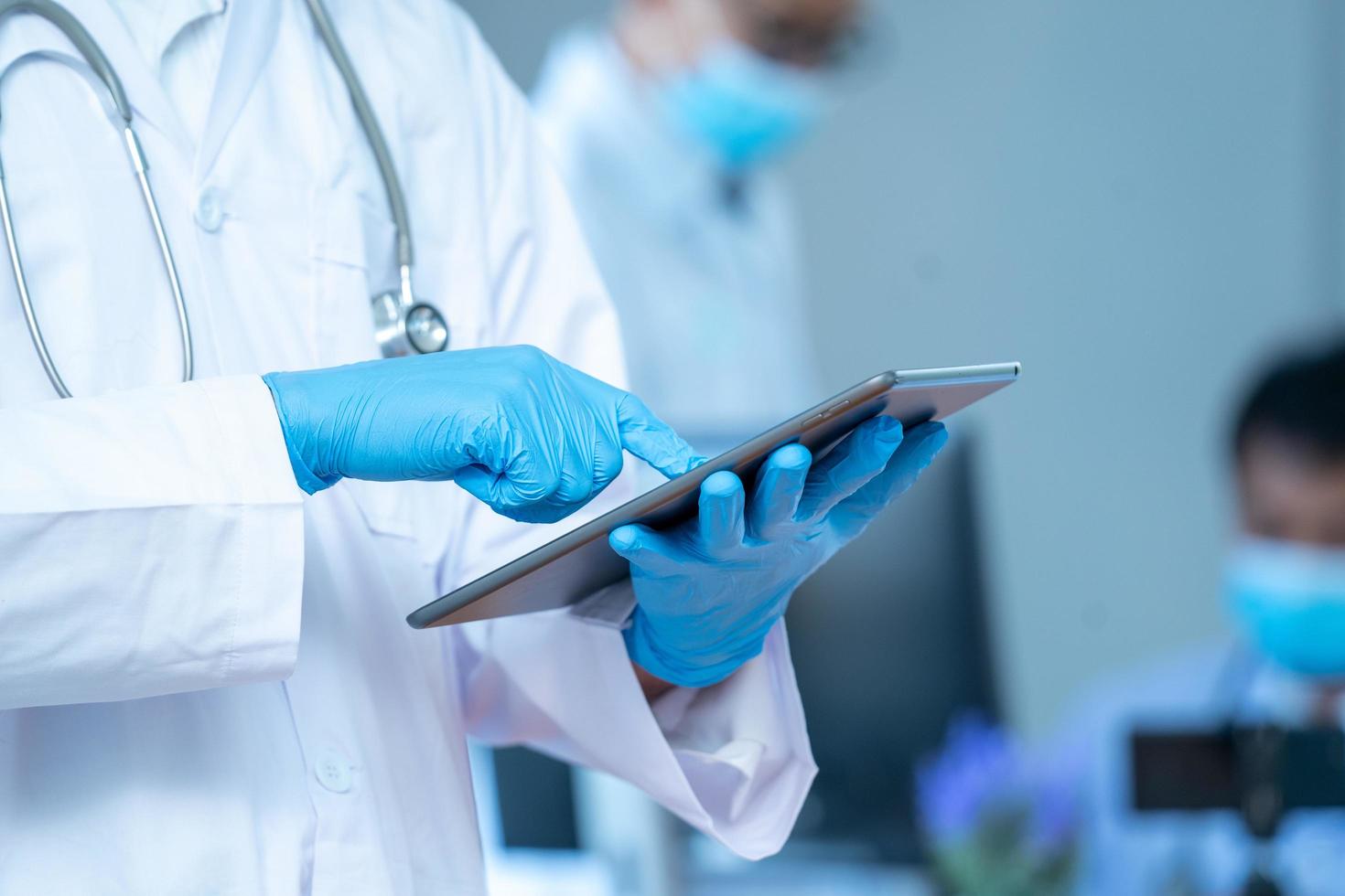 Person with gloves and lab coat and tablet photo