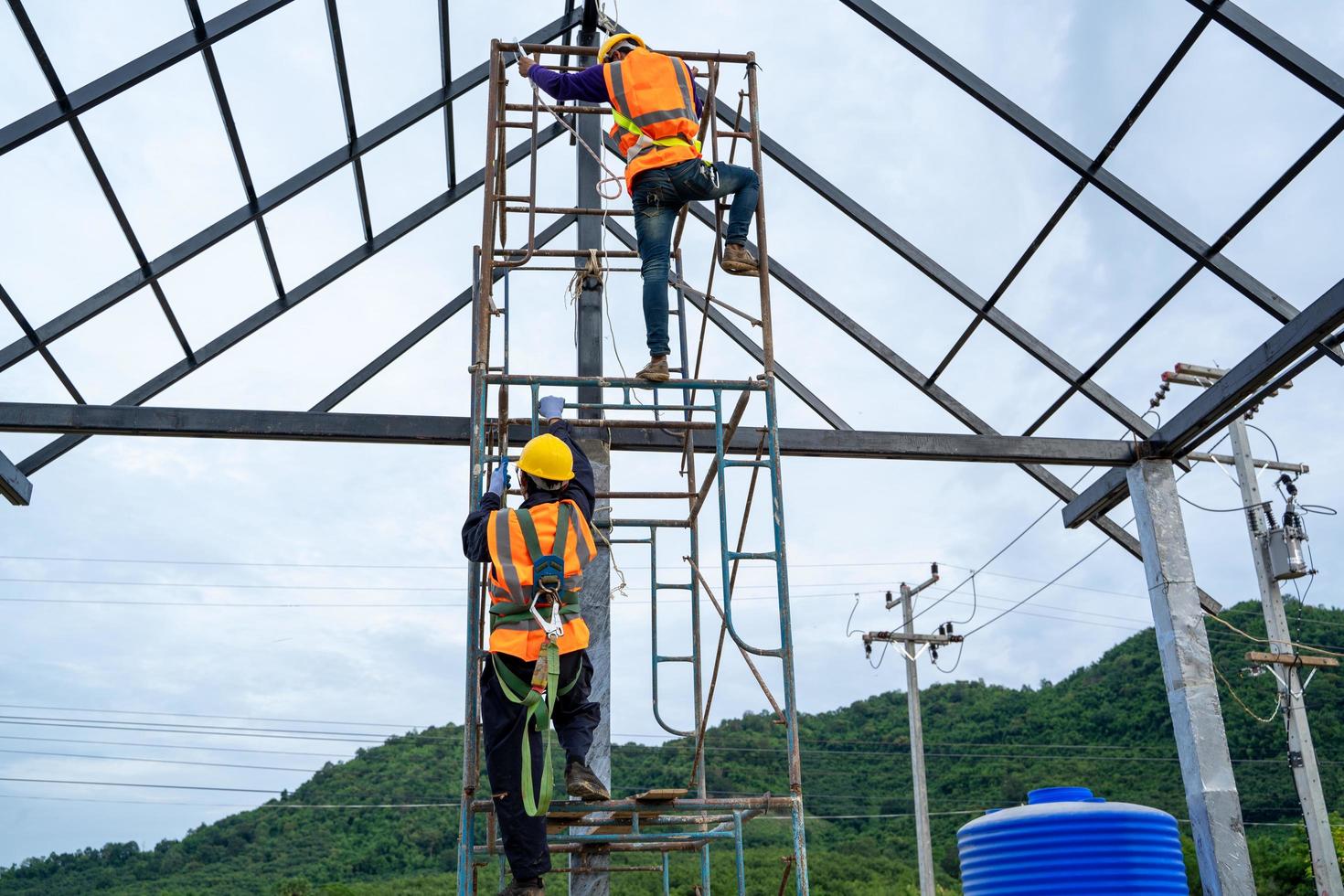 Construction workers wearing safety harnesses on scaffolds photo