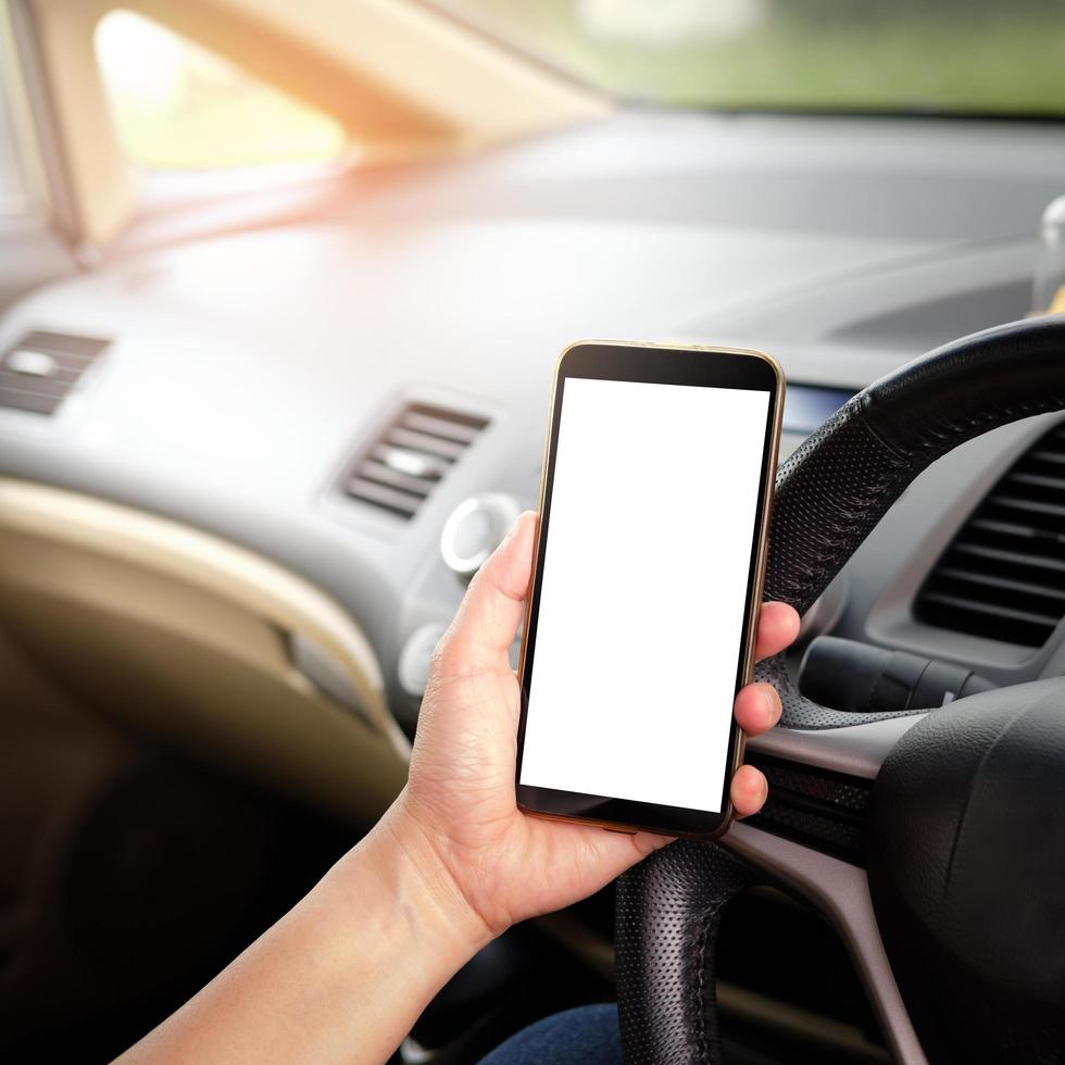 Hand holding smartphone in car photo