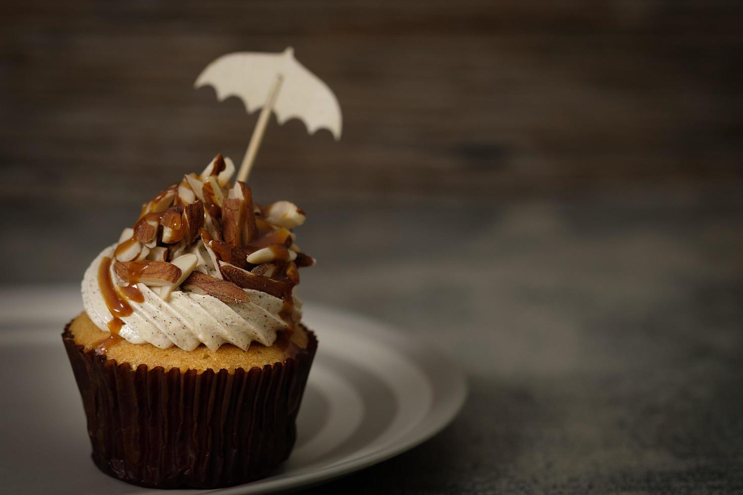 cupcake cubierto con glaseado, almendras y caramelo foto