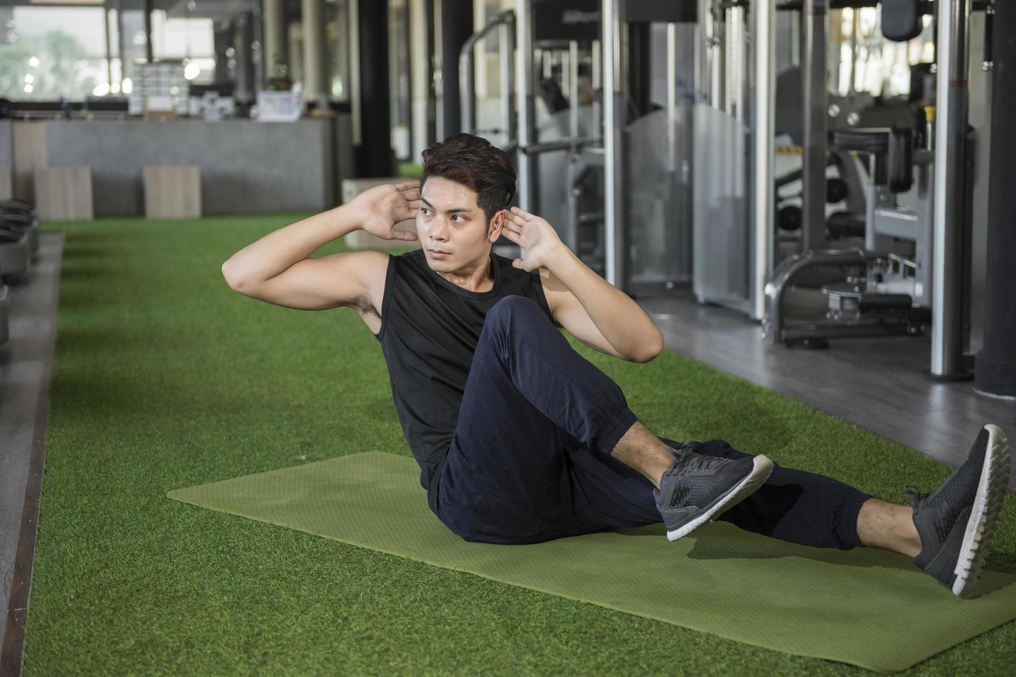 Man doing cruches in a gym photo