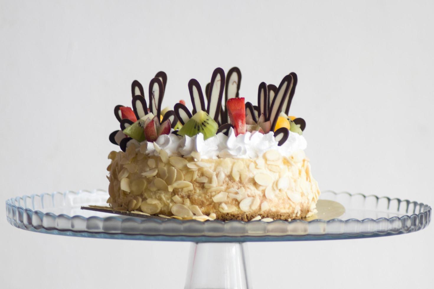 Brown and white icing covered cake with fruit photo