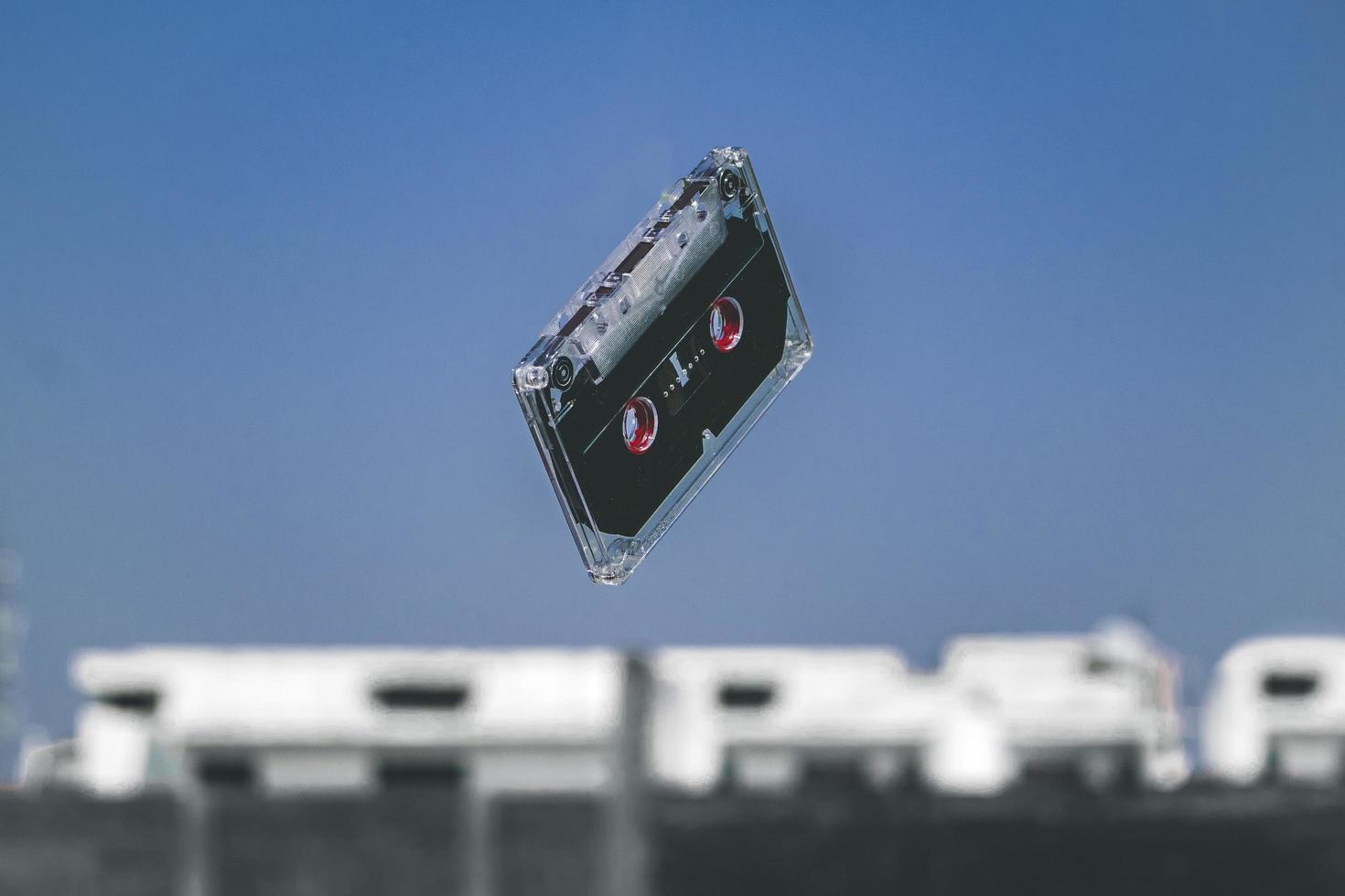 Black cassette tape in mid-air photo