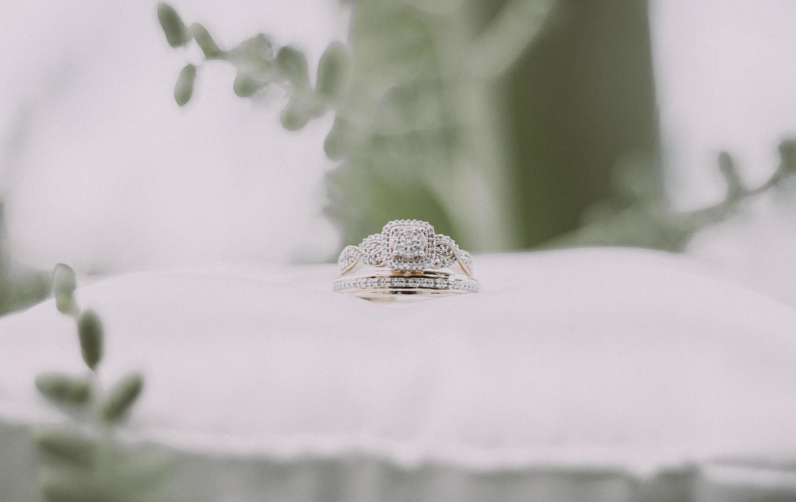 Silver and gold ring on white pillow top photo