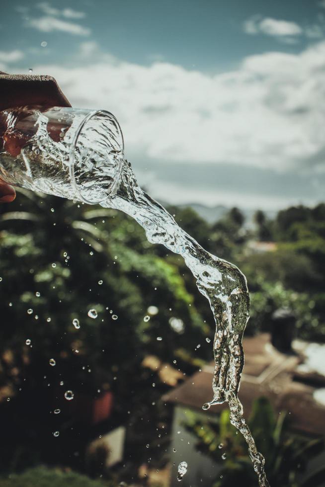 A person pouring a glass of water photo