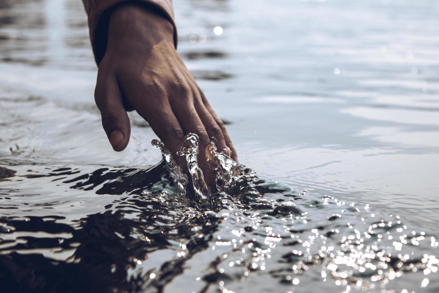 primer plano de una mano corriendo por el agua foto