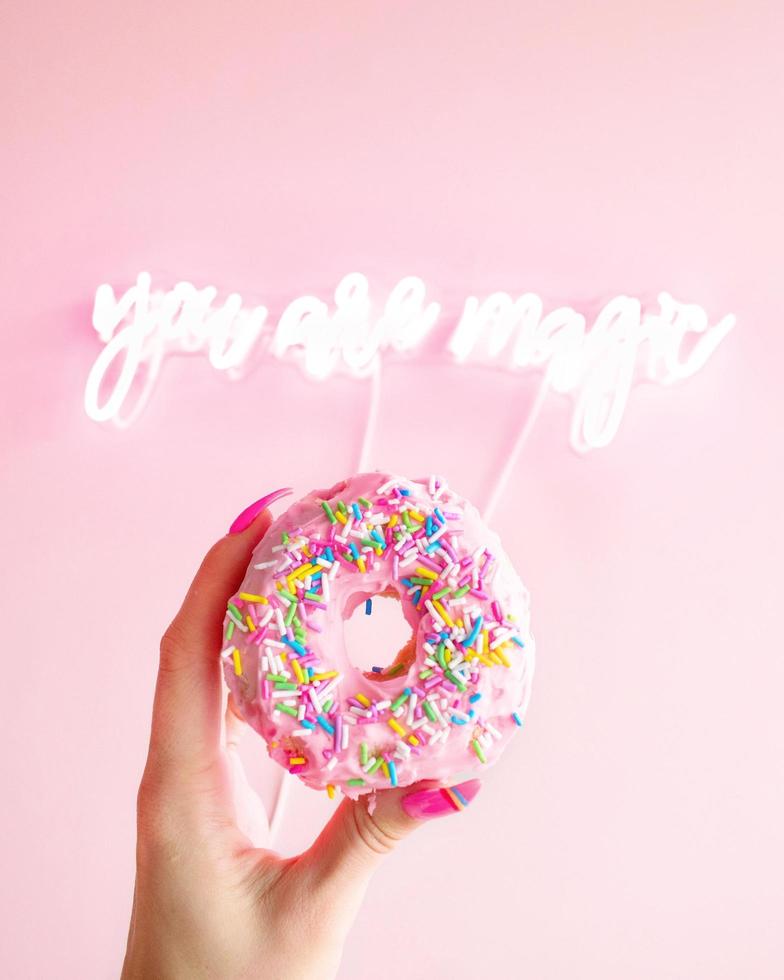 Woman holding donut with sprinkles photo