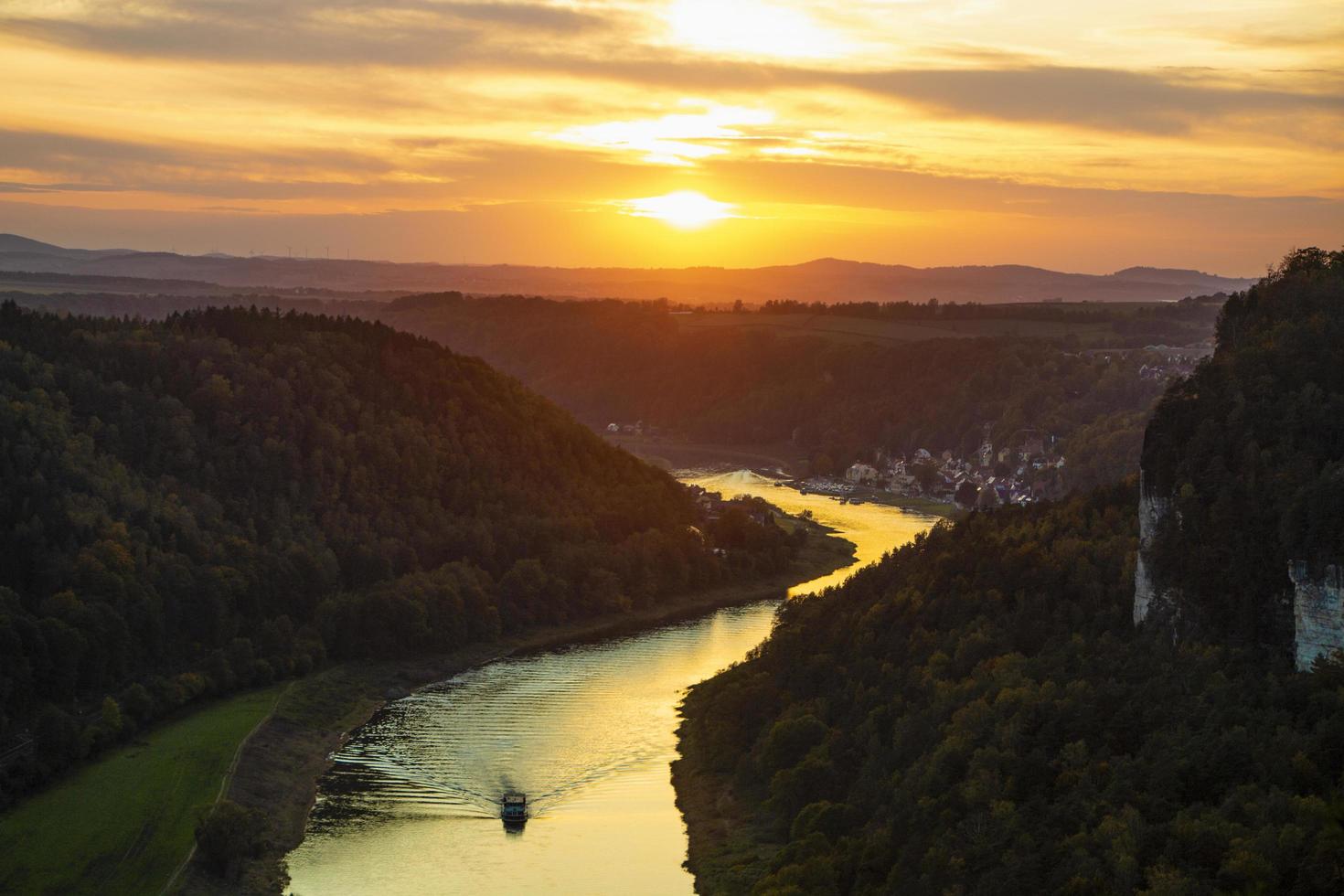 Boat going down river during sunset. photo