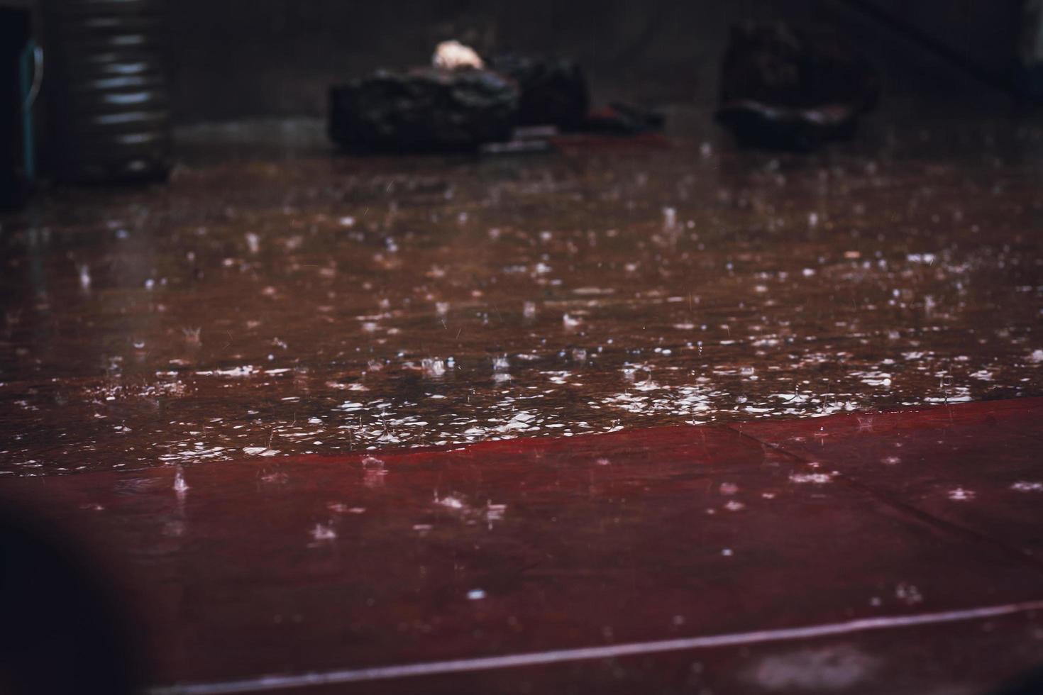 Rain drops falling on wooden parquet floor photo