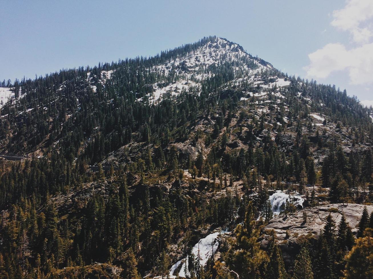 Mountain with green trees under blue sky photo