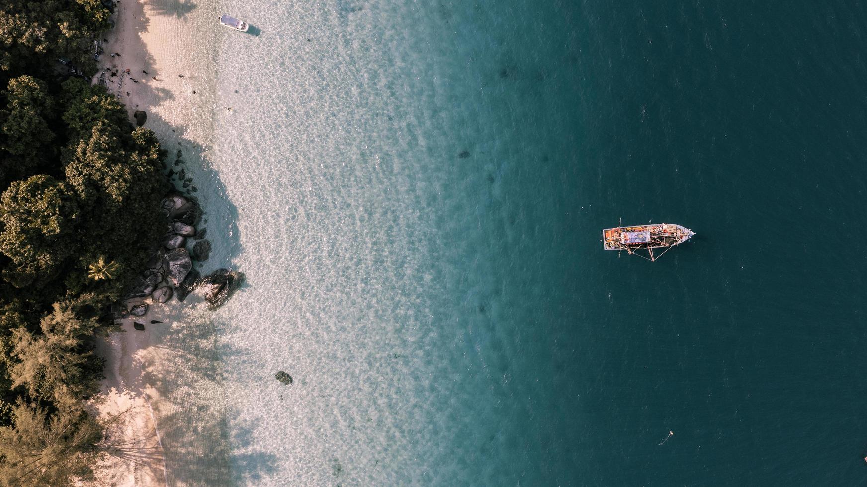 Aerial view of boat in ocean near a beach photo