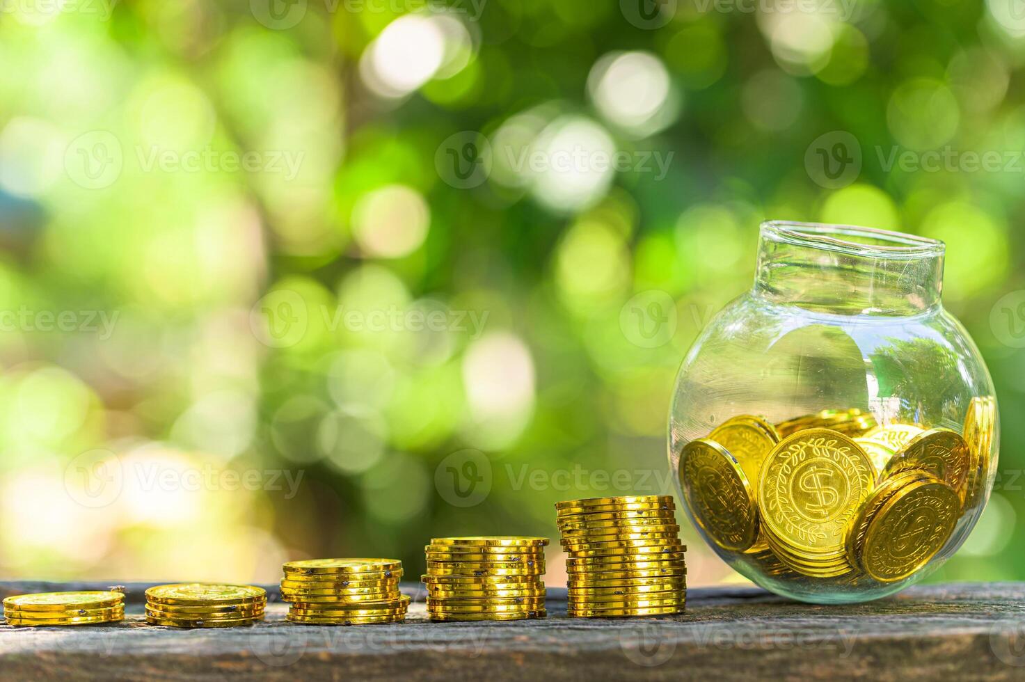 Stack of gold coins and jar on table outside photo
