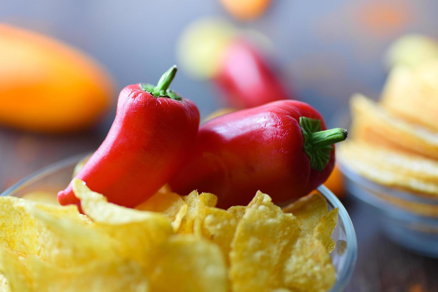 Red chili peppers on potato chips in bowl photo