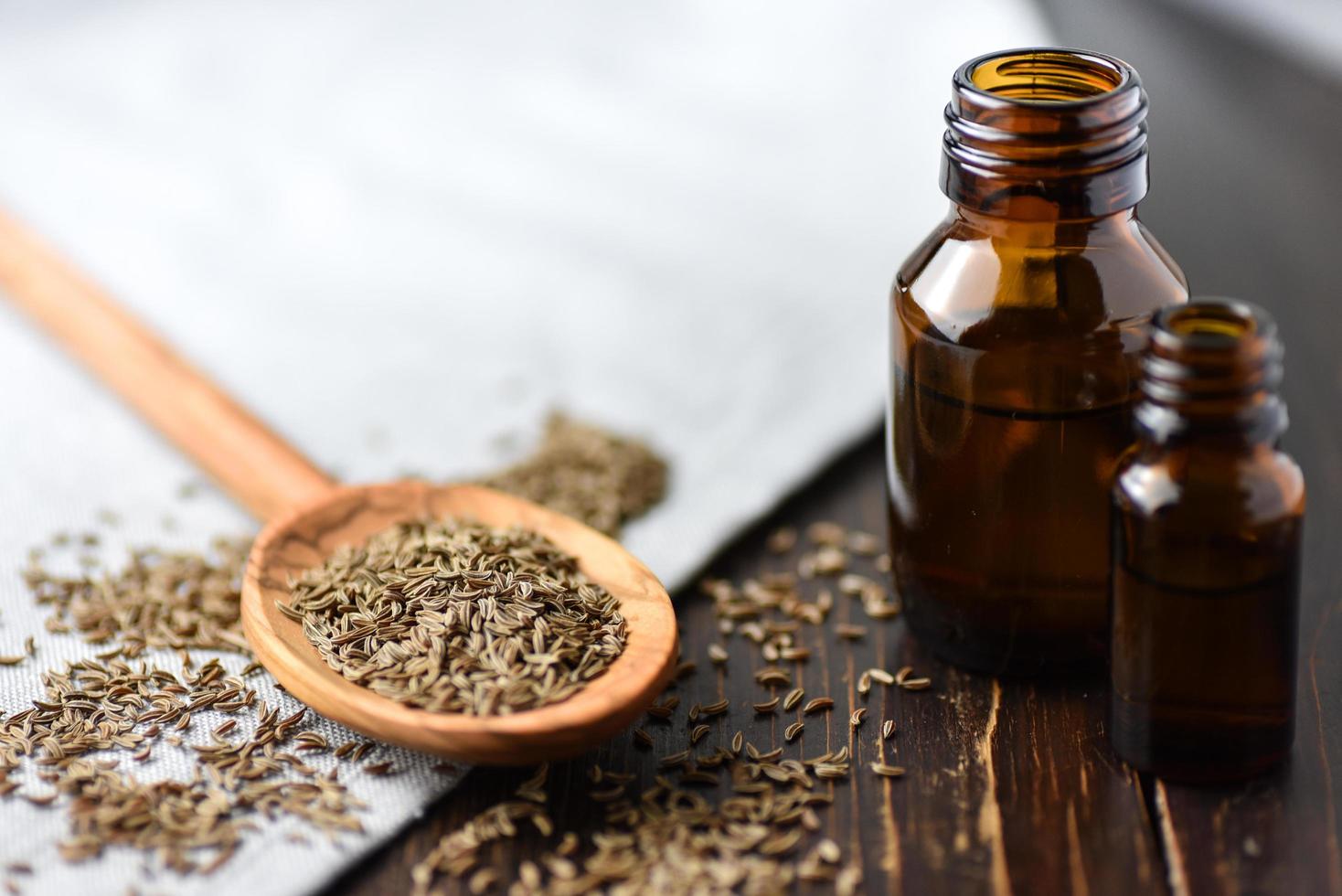 Cumin seeds and oil in bottles photo