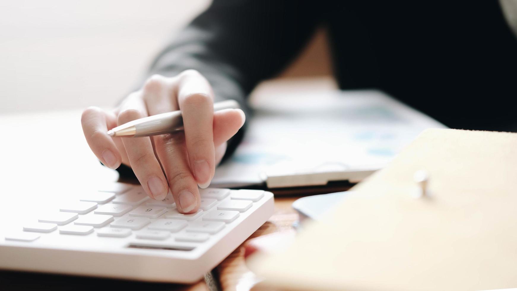 Close up of businesswoman using calculator  photo