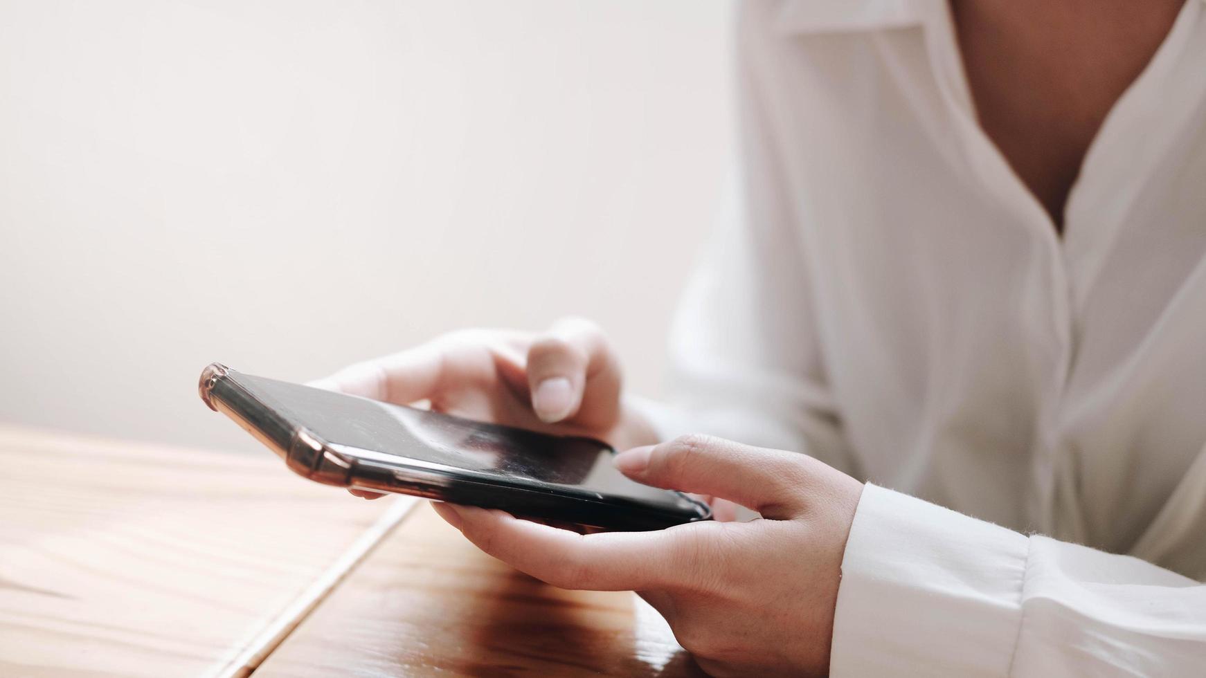 joven mujer asiática que trabaja con teléfonos inteligentes foto