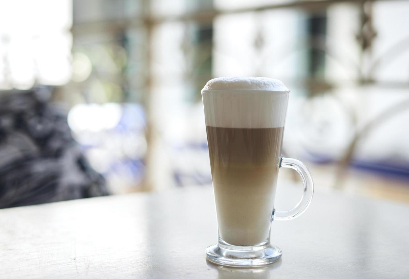 Latte in clear mug on table photo