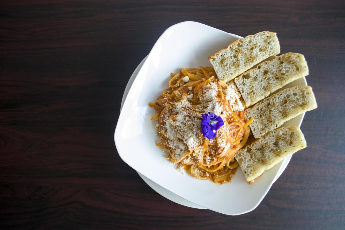 Pasta dish with sliced bread photo