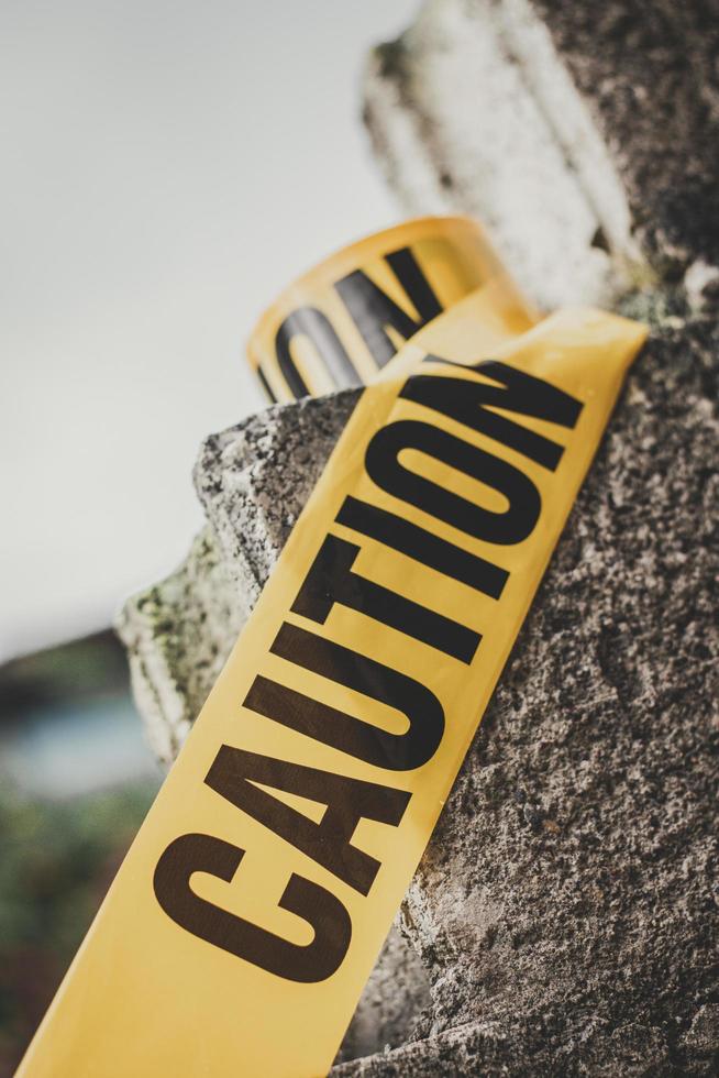 Black and yellow caution tape roll on cement block. photo