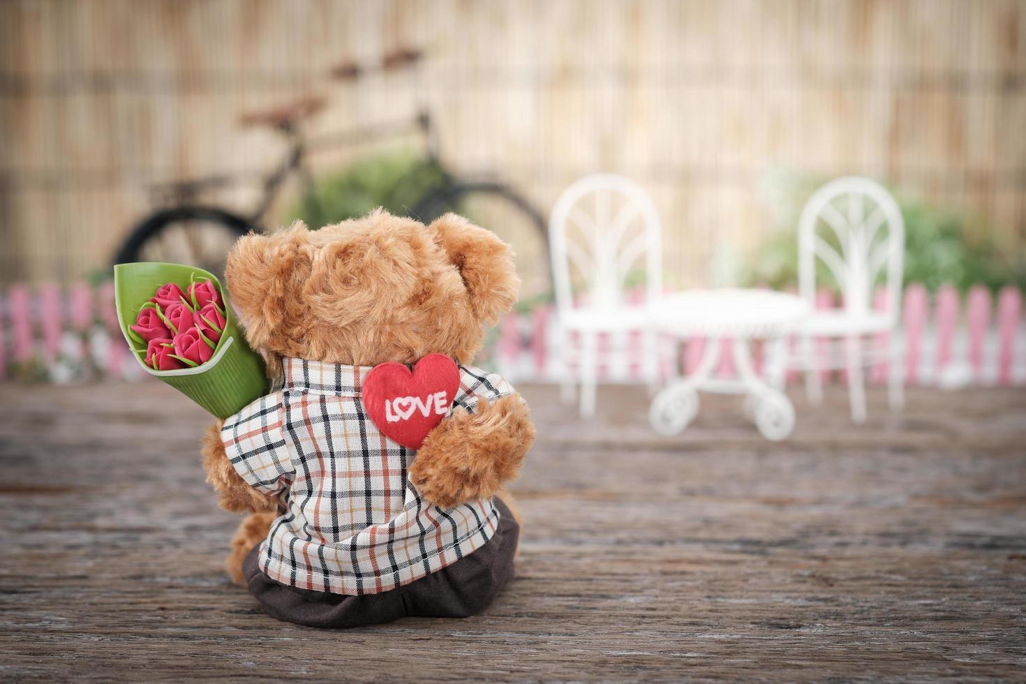 Teddy bear holding flowers photo