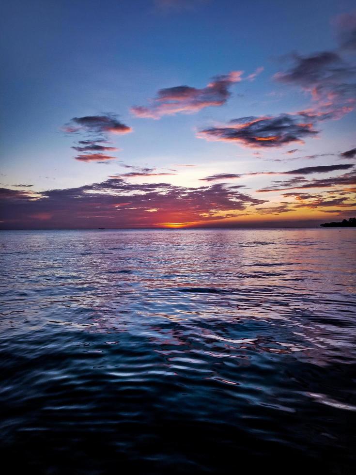 Cumulus clouds above ocean during sunset photo