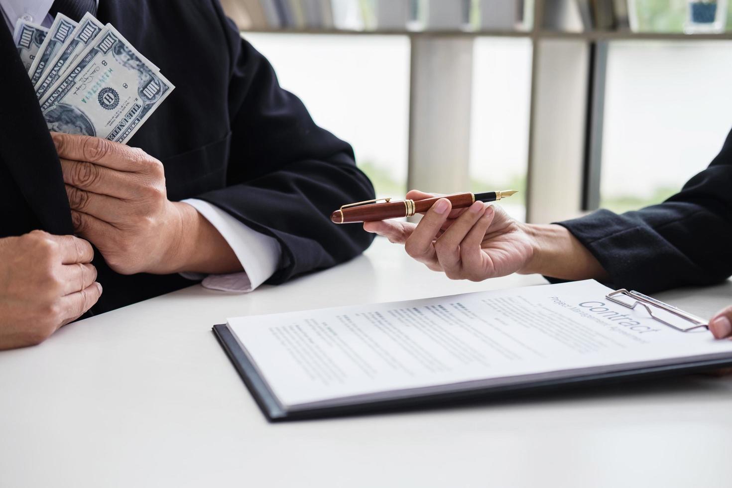 Businessman giving money while making deal  photo