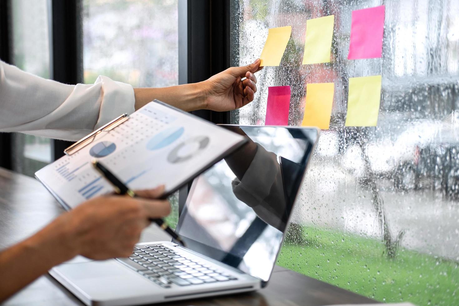 Business person reaches for sticky note paper reminder  photo