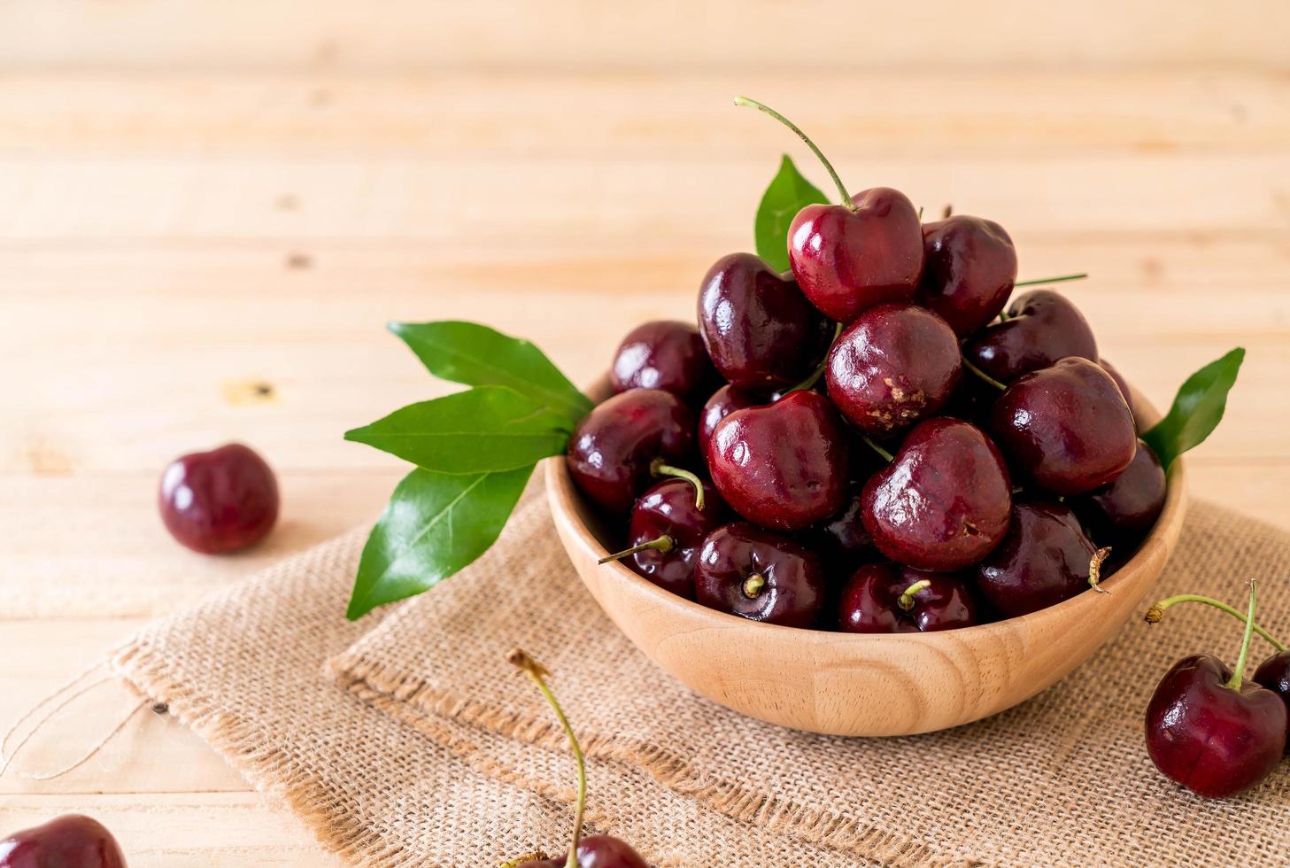 cereza fresca en un cuenco de madera foto