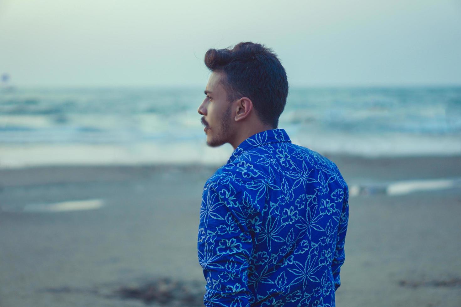 Young man walking on beach photo