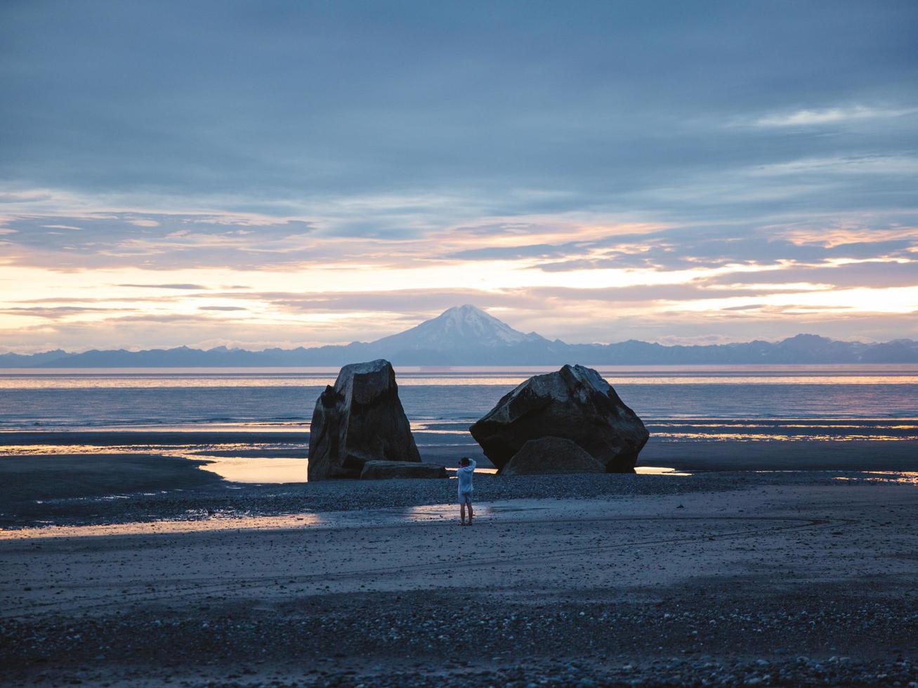 Fotógrafo de pie en la playa en Alaska foto