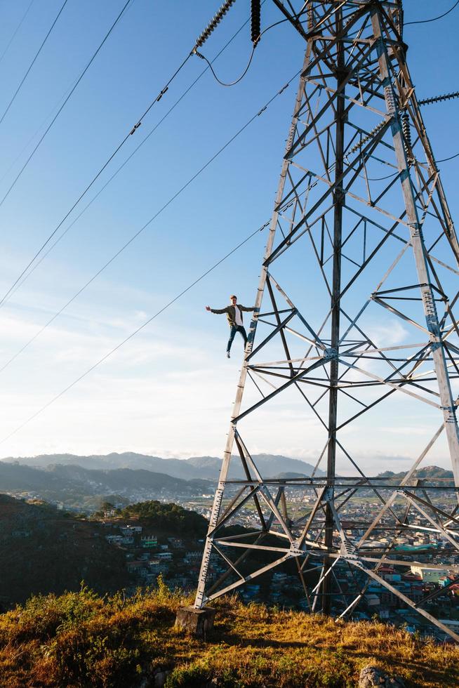 Man hanging from electrical tower photo