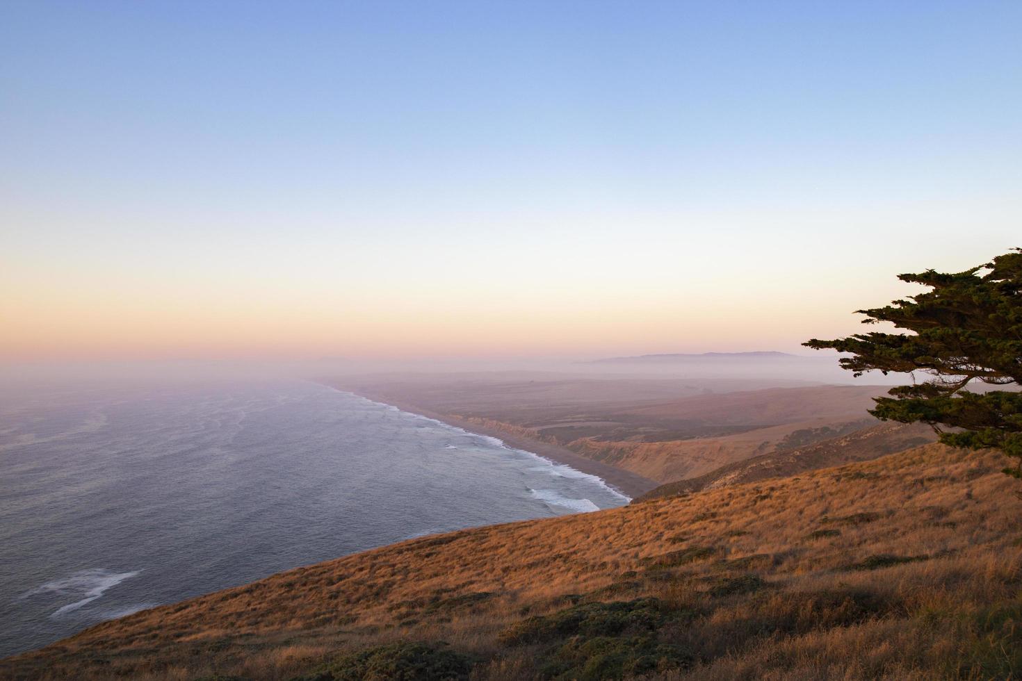 Hills and shoreline by water photo