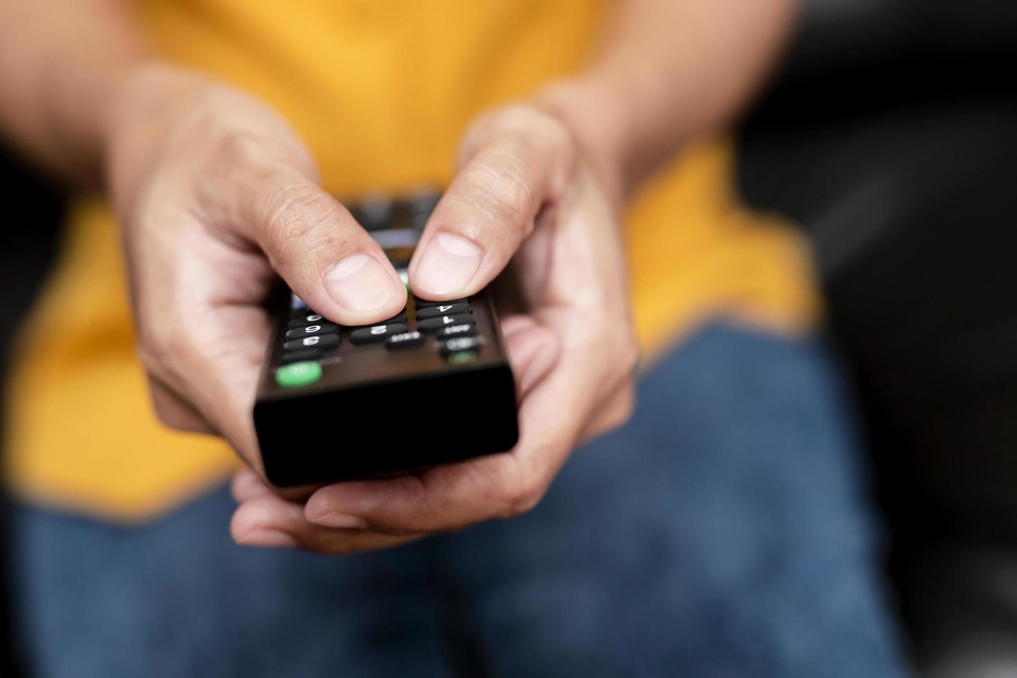 Close-up of person holding remote photo