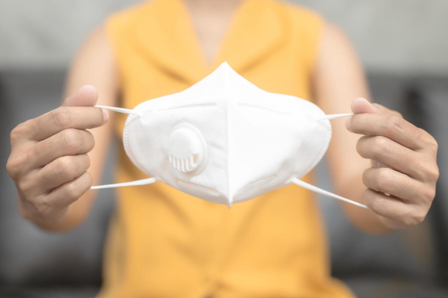 Woman holding out white mask photo