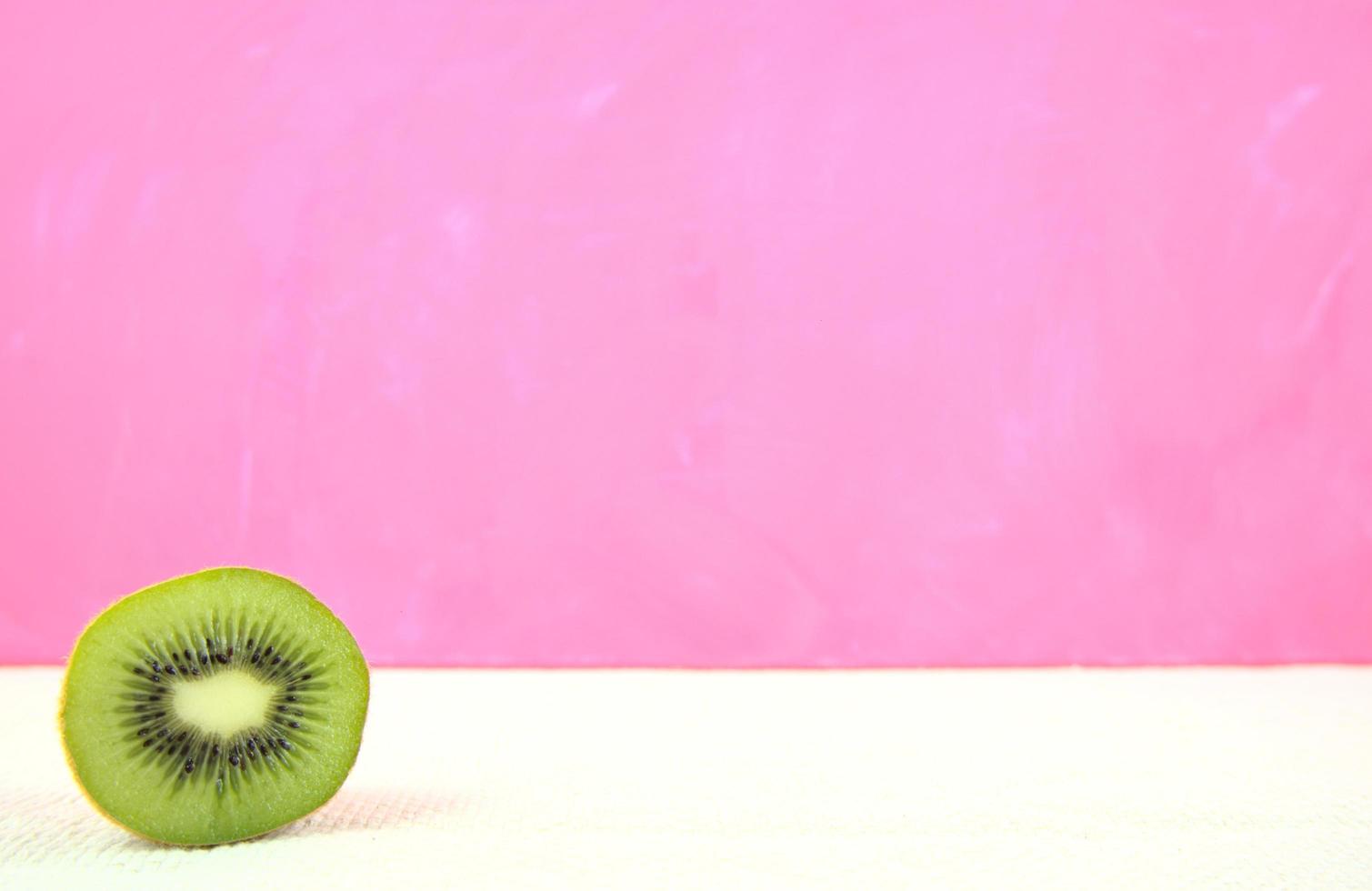 kiwi en rodajas sobre fondo rosa foto