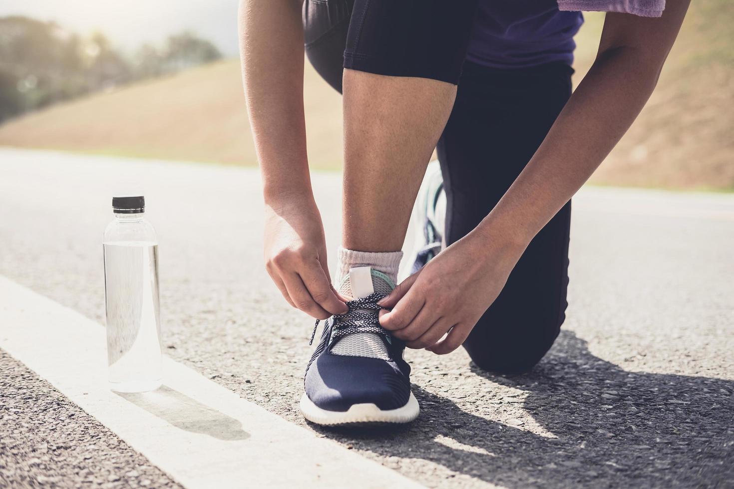 Estilo de vida saludable, corredor atar zapatillas para correr preparándose para la carrera en la pista de atletismo concepto de bienestar de entrenamiento foto