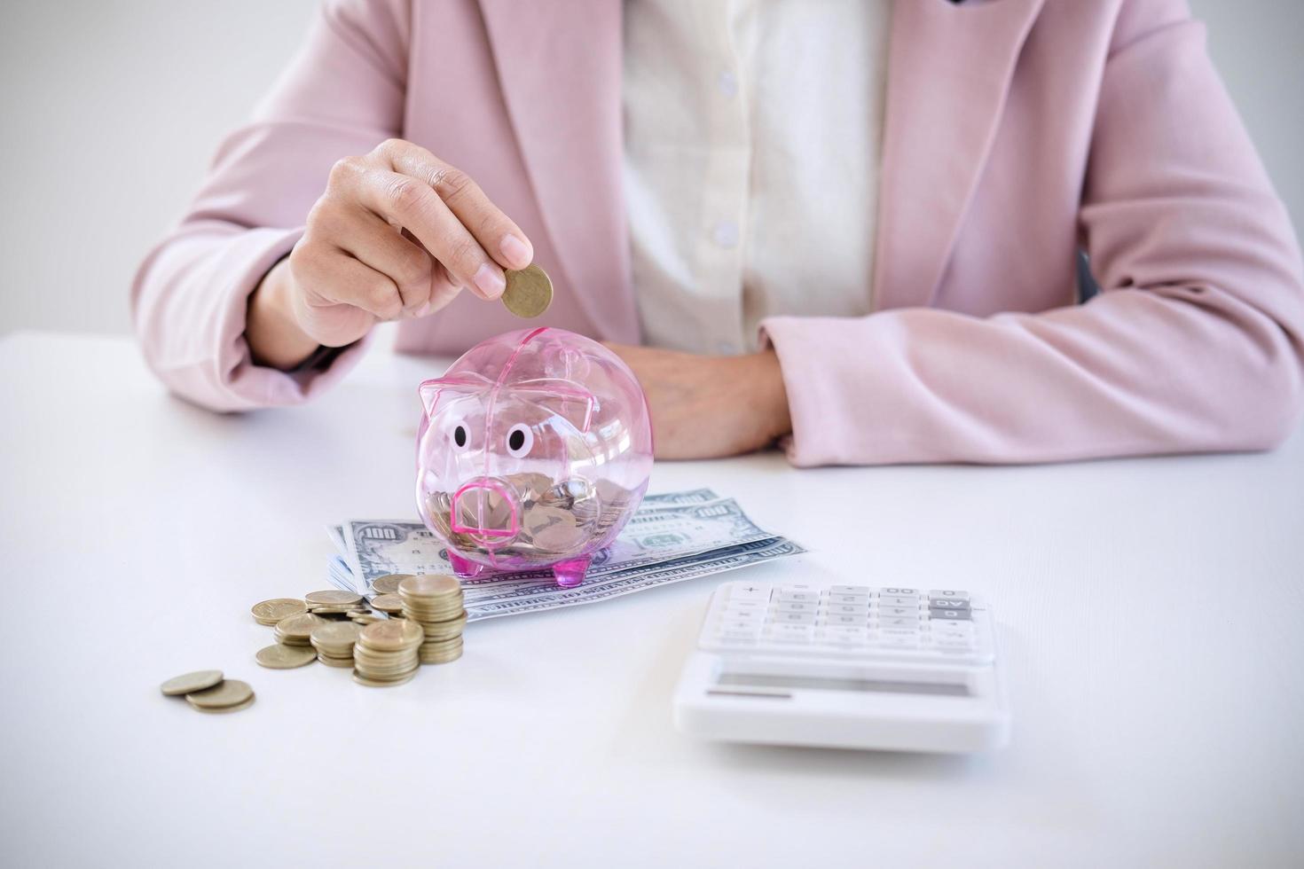 mujer de negocios, poner monedas, en, hucha foto