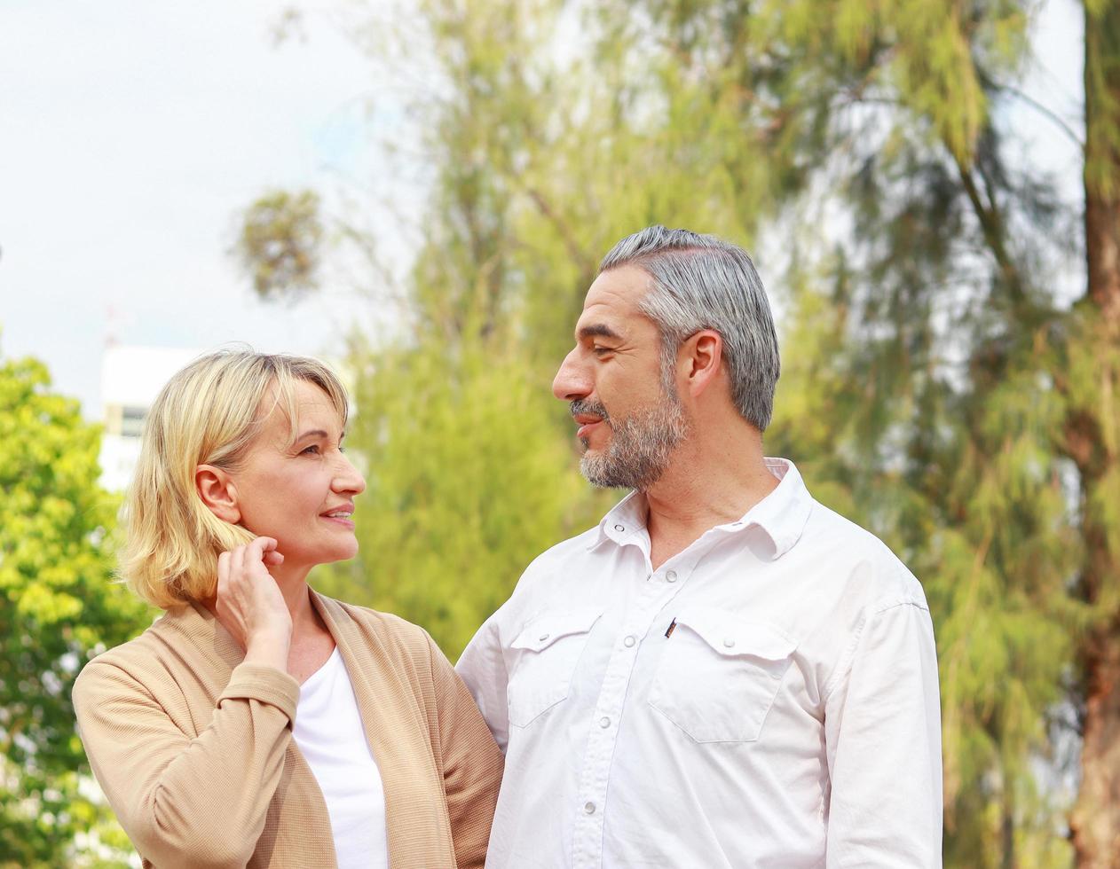 Mature couple happily strolling in park photo