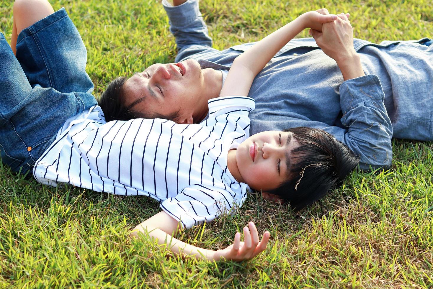 padre e hijo tumbado en la hierba foto