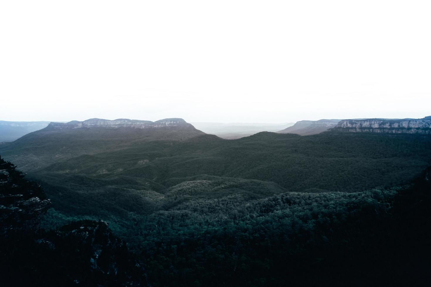 montañas verdes bajo el cielo blanco foto