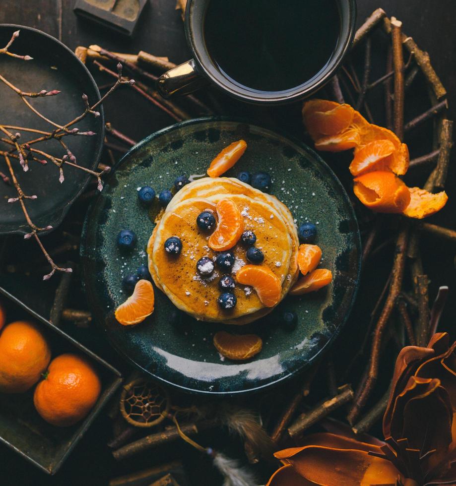 Panqueques con rodajas de naranja y arándanos en la placa foto