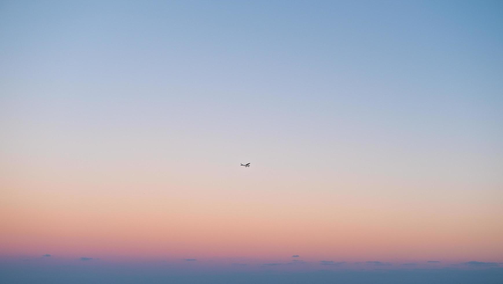 Airplane flying against colorful sky photo