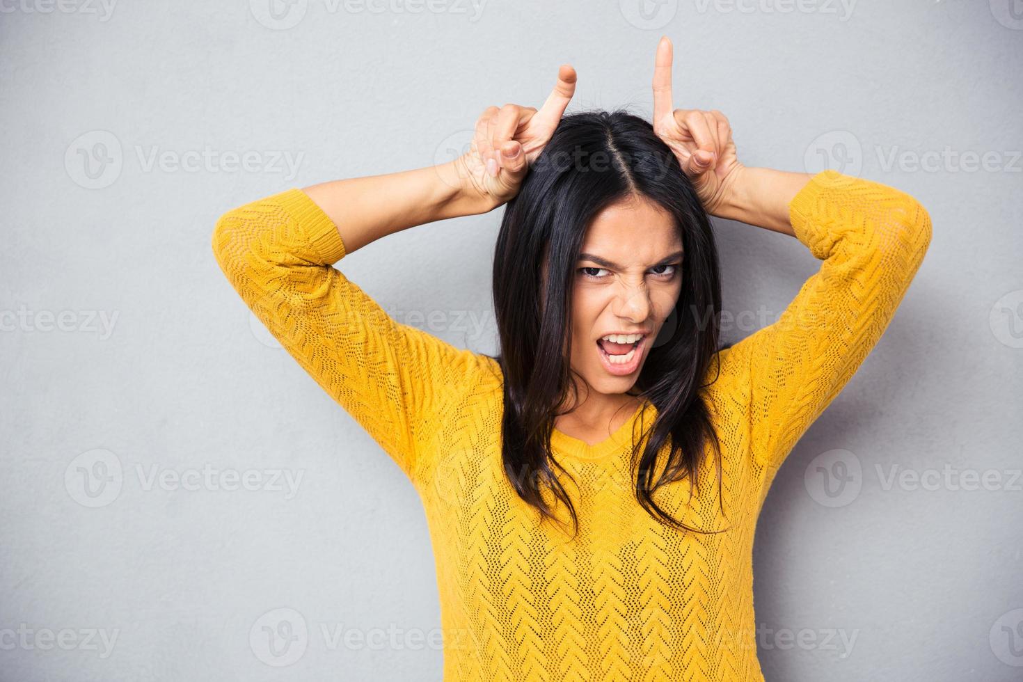 mujer mostrando cuernos con sus dedos foto