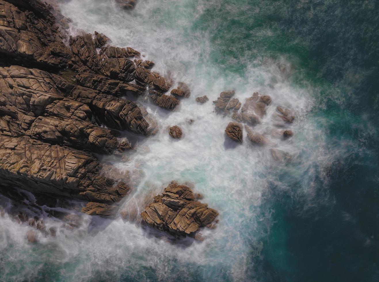 larga exposición de olas salpicando rocas foto