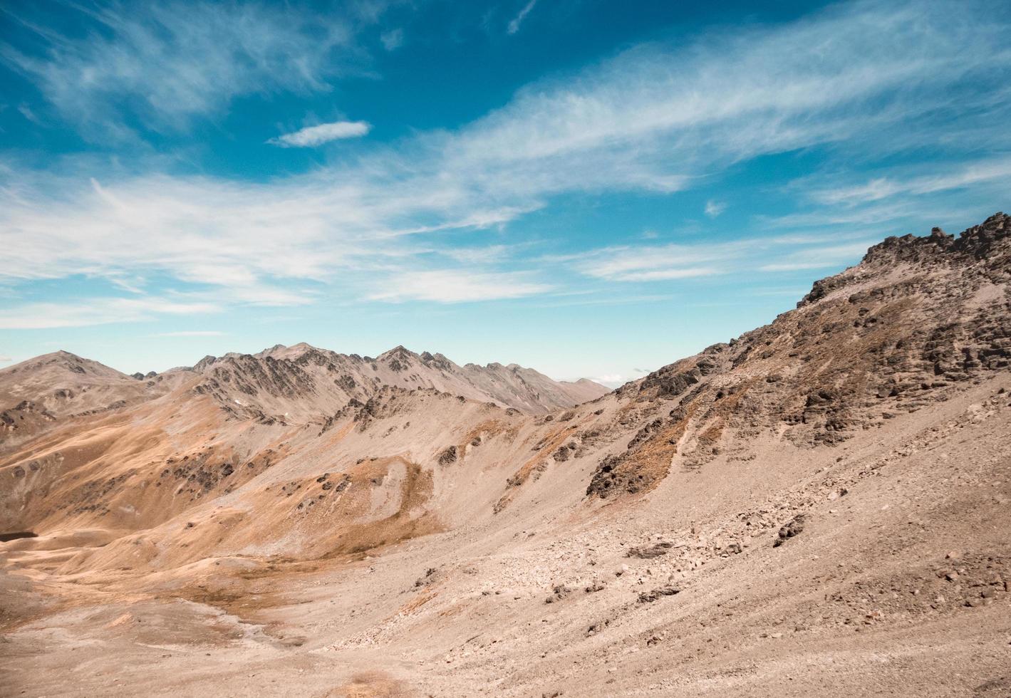 Brown hills under cloudy blue sky photo